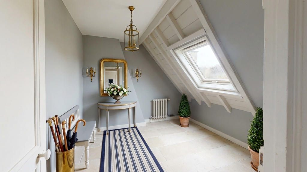 Refined French vestibule with grey walls and gilded mirror